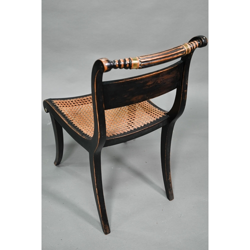 914 - A pair of Regency brass mounted ebonised framed cane seat side chairs, on sabre front legs (2)