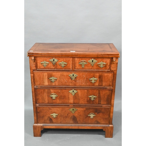 916 - An 18th century feather-banded walnut bachelors chest, the fold over top over two short and three lo... 