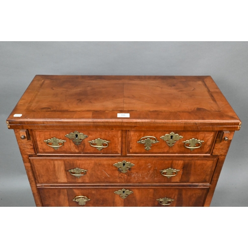 916 - An 18th century feather-banded walnut bachelors chest, the fold over top over two short and three lo... 