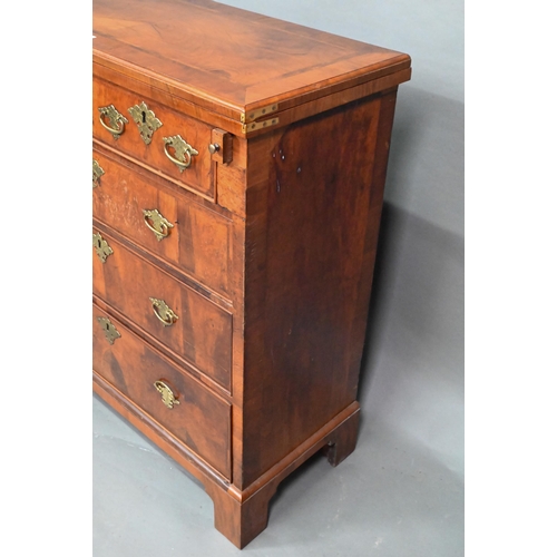 916 - An 18th century feather-banded walnut bachelors chest, the fold over top over two short and three lo... 