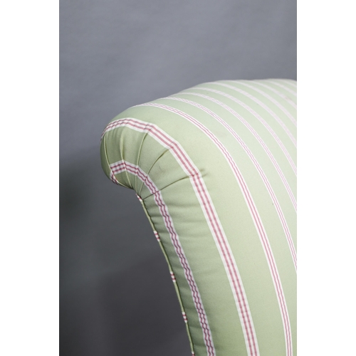 917 - A late Victorian armchair, well re-upholstered in striped pale green/red fabric, raised on castors