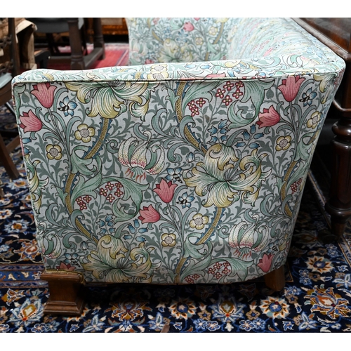 922 - An Arts & Crafts period Liberty style sofa, well upholstered in piped William Morris fabric, wit... 