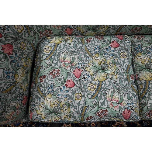 922 - An Arts & Crafts period Liberty style sofa, well upholstered in piped William Morris fabric, wit... 