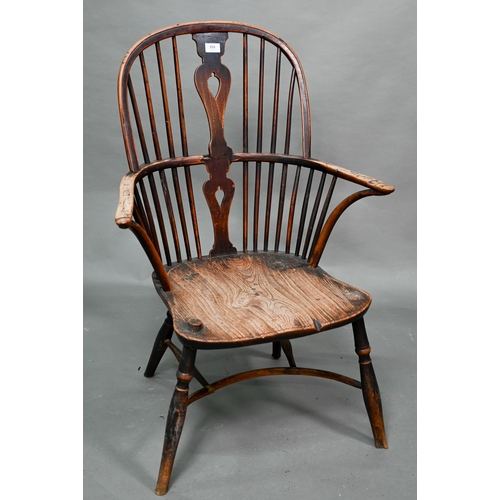 933 - A 19th century yew and elm seat Windsor stick-back elbow chair, the arms carved with various student... 