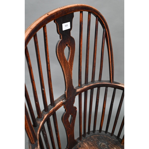 933 - A 19th century yew and elm seat Windsor stick-back elbow chair, the arms carved with various student... 