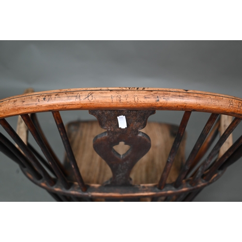 933 - A 19th century yew and elm seat Windsor stick-back elbow chair, the arms carved with various student... 