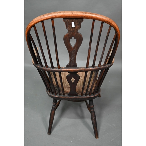 933 - A 19th century yew and elm seat Windsor stick-back elbow chair, the arms carved with various student... 