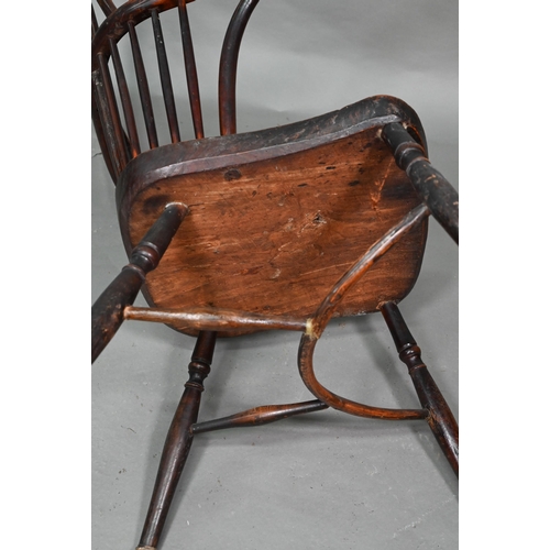 933 - A 19th century yew and elm seat Windsor stick-back elbow chair, the arms carved with various student... 