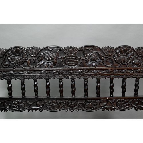 934 - A profusely carved and moulded colonial ebonised hardwood sofa bench, with cane panelled seat (with ... 