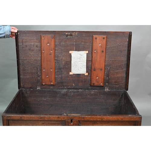 938 - A small oak mule chest, the two plank top over a twin panel front carved 'H C 1699', over a and full... 