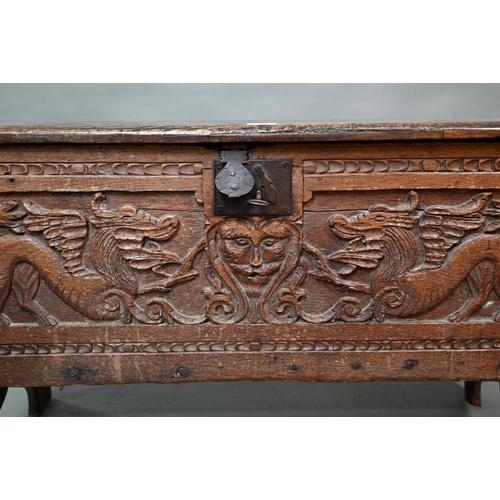 939 - A 17th century oak six plank coffer, with iron staple lock and key, the relief carved front centred ... 