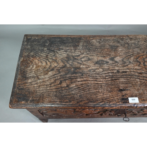 939 - A 17th century oak six plank coffer, with iron staple lock and key, the relief carved front centred ... 