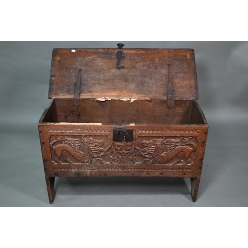 939 - A 17th century oak six plank coffer, with iron staple lock and key, the relief carved front centred ... 