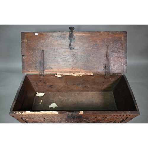 939 - A 17th century oak six plank coffer, with iron staple lock and key, the relief carved front centred ... 