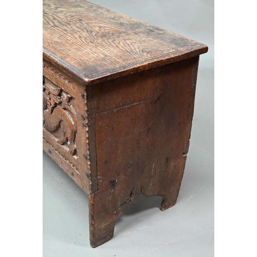 939 - A 17th century oak six plank coffer, with iron staple lock and key, the relief carved front centred ... 