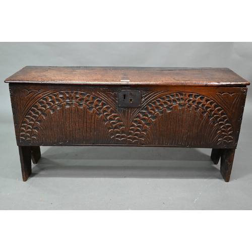 940 - An English oak Commonwealth period six plank coffer, the front fully carved with twin lunettes, 106 ... 