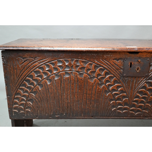 940 - An English oak Commonwealth period six plank coffer, the front fully carved with twin lunettes, 106 ... 