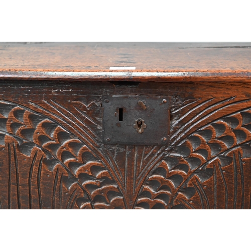 940 - An English oak Commonwealth period six plank coffer, the front fully carved with twin lunettes, 106 ... 