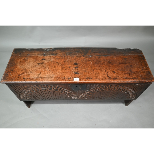 940 - An English oak Commonwealth period six plank coffer, the front fully carved with twin lunettes, 106 ... 