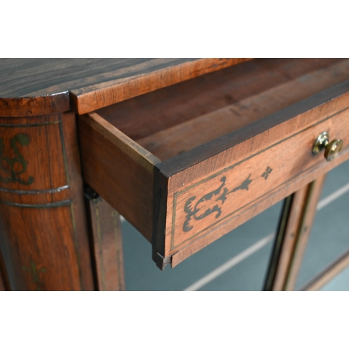 945 - A Regency brass inlaid rosewood side cabinet, the full width frieze drawer over a pair of glazed-in ... 