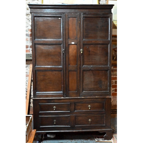 948 - An 18th century and later composed oak two section linen cupboard, the pair of joint framed triple p... 