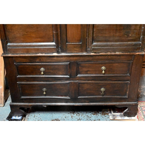 948 - An 18th century and later composed oak two section linen cupboard, the pair of joint framed triple p... 