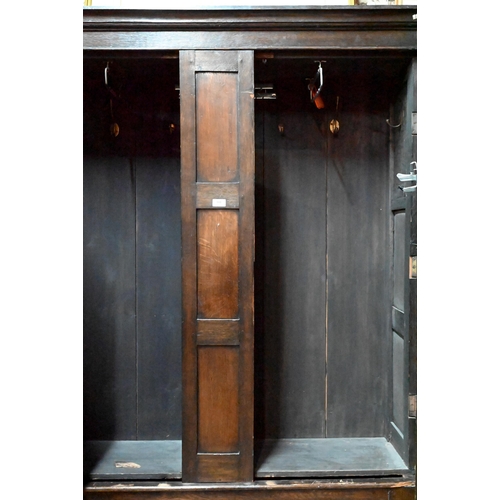 948 - An 18th century and later composed oak two section linen cupboard, the pair of joint framed triple p... 