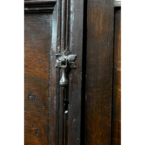 948 - An 18th century and later composed oak two section linen cupboard, the pair of joint framed triple p... 