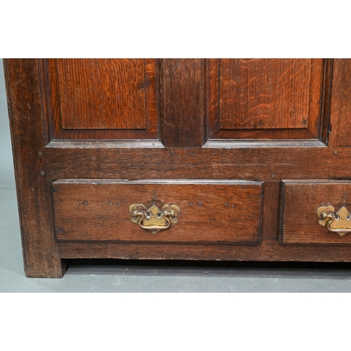 949 - An 18th century oak mule chest, the three plank top over four fielded arched panels and three drawer... 