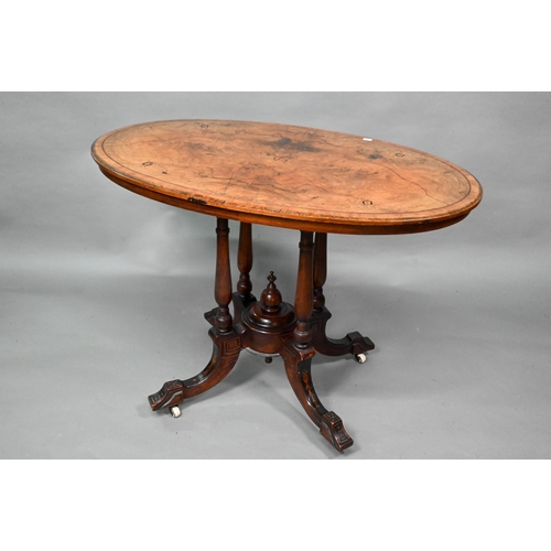 956 - A Victorian inlaid figured walnut centre table, the oval top raised on four to swept legs, on castor... 