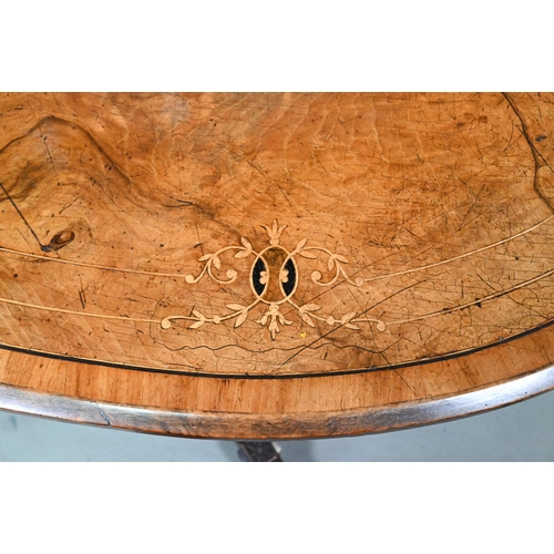 956 - A Victorian inlaid figured walnut centre table, the oval top raised on four to swept legs, on castor... 