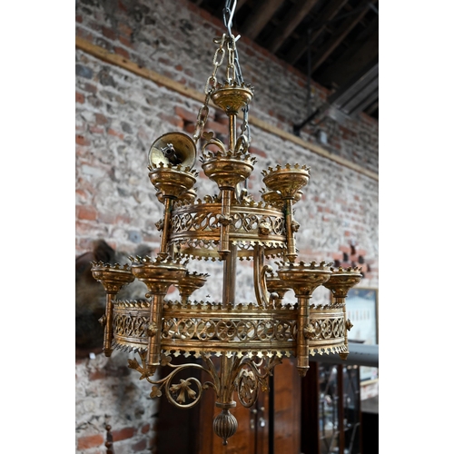 957 - A Gothic brass hanging circular two graduated tier candelabra, of ecclesiastical form, late 19th cen... 