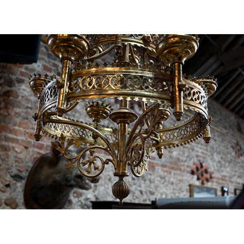 957 - A Gothic brass hanging circular two graduated tier candelabra, of ecclesiastical form, late 19th cen... 