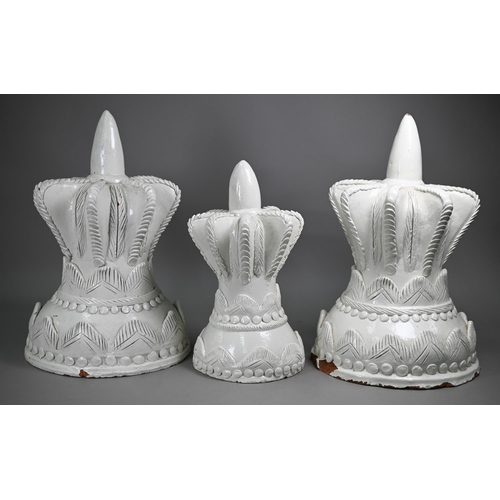 976 - Three white-painted terracotta crown-shaped finials, 50/40 cm