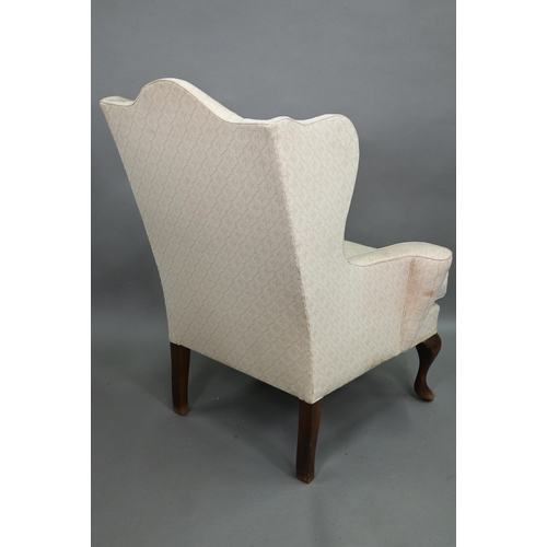 923A - A late 19th century wing armchair in the George II style, with out-swept arms, raised on walnut cabr... 