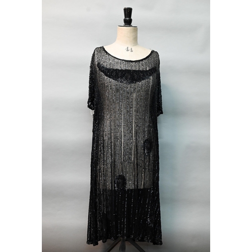 1287 - Two 1920s black 'flapper' dresses, heavily beaded and embellished on fine net, one with beaded cord ... 