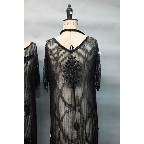 1287 - Two 1920s black 'flapper' dresses, heavily beaded and embellished on fine net, one with beaded cord ... 