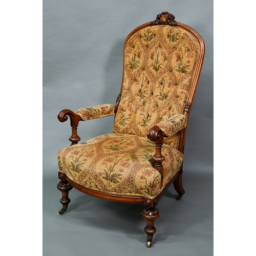 850A - A Victorian walnut framed open armchair with carved crest, deep buttoned back and stuff-over seats, ... 