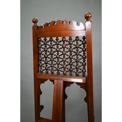 874A - An Edwardian pictue easel in the Liberty manner, with shaped frame, strut back and decorative 'spind... 