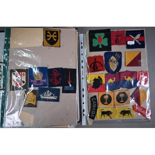 1058 - Two folders of British military WWII and other cloth, patch, shoulder titles and other insignia, var... 