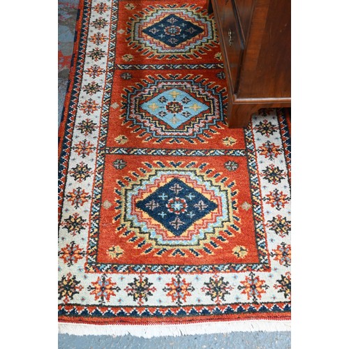 1218 - A contemporary Indo-Persian Kazak runner, burnt orange ground with five alternating lozenge design, ... 