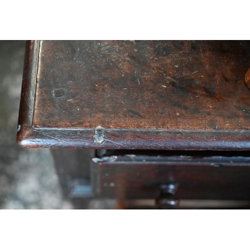 901 - An 18th century oak three drawer low dresser, very dark surface finish, raised on three turned front... 