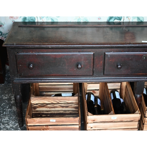 901 - An 18th century oak three drawer low dresser, very dark surface finish, raised on three turned front... 