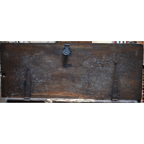 939 - A 17th century oak six plank coffer, with iron staple lock and key, the relief carved front centred ... 