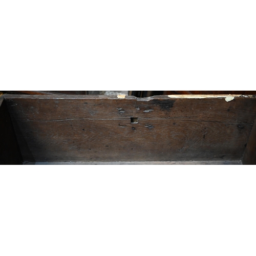 939 - A 17th century oak six plank coffer, with iron staple lock and key, the relief carved front centred ... 