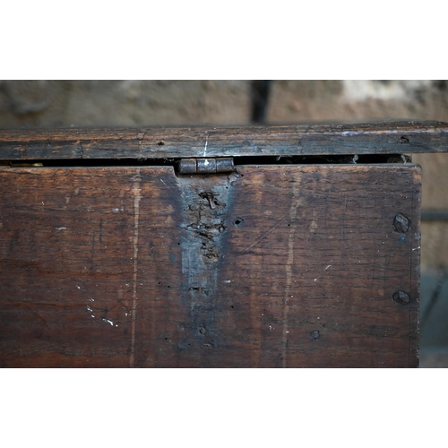 939 - A 17th century oak six plank coffer, with iron staple lock and key, the relief carved front centred ... 