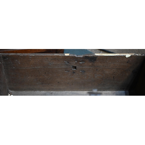 939 - A 17th century oak six plank coffer, with iron staple lock and key, the relief carved front centred ... 