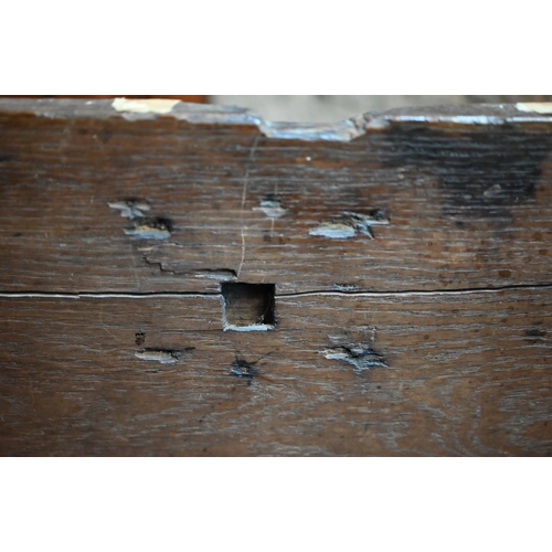 939 - A 17th century oak six plank coffer, with iron staple lock and key, the relief carved front centred ... 