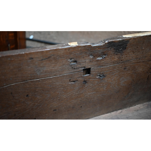 939 - A 17th century oak six plank coffer, with iron staple lock and key, the relief carved front centred ... 