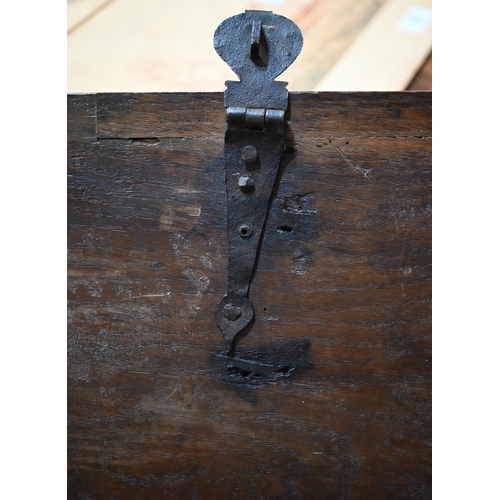 939 - A 17th century oak six plank coffer, with iron staple lock and key, the relief carved front centred ... 